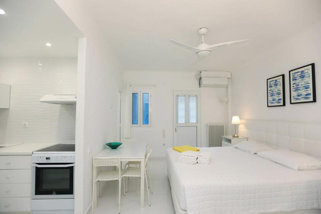 a white room with a bed and a table at Adikri Villas & Suites in Tourlos