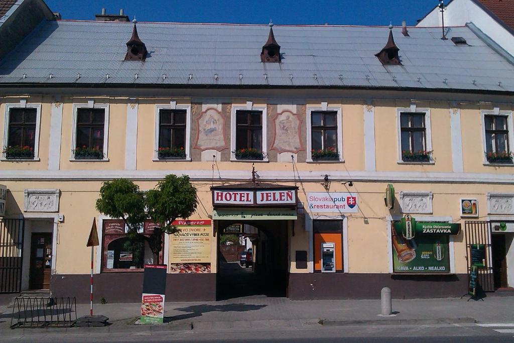 a building on a street with a hotel at Hotel Jeleň in Pezinok