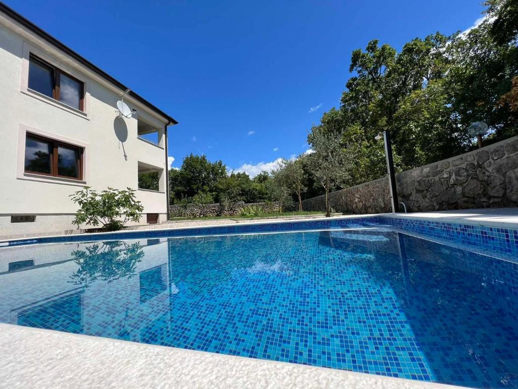 - une piscine en face d'une maison dans l'établissement Apartman David, à Rijeka