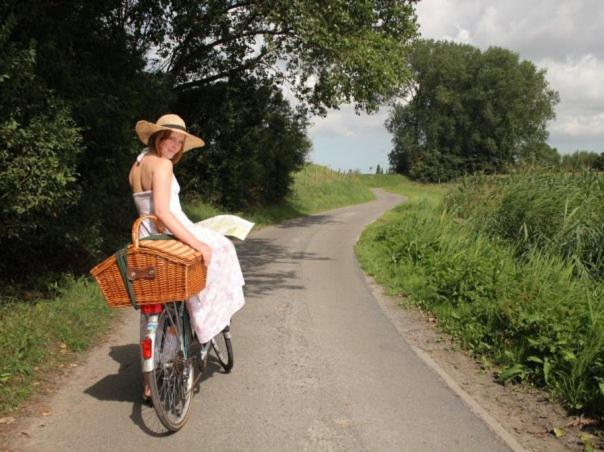 Una donna che va in bicicletta lungo una strada sterrata. di Logie CountryHeart zonder ontbijt a Sint-Laureins