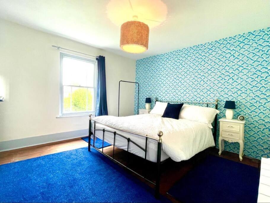 a bedroom with a bed and a blue wall at Little Tern - Rye Harbour - Games room & Office in Rye Harbour