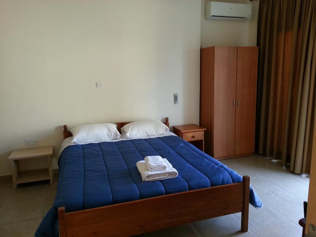 a bedroom with a blue bed with two towels on it at St. Lazaros House in Larnaca