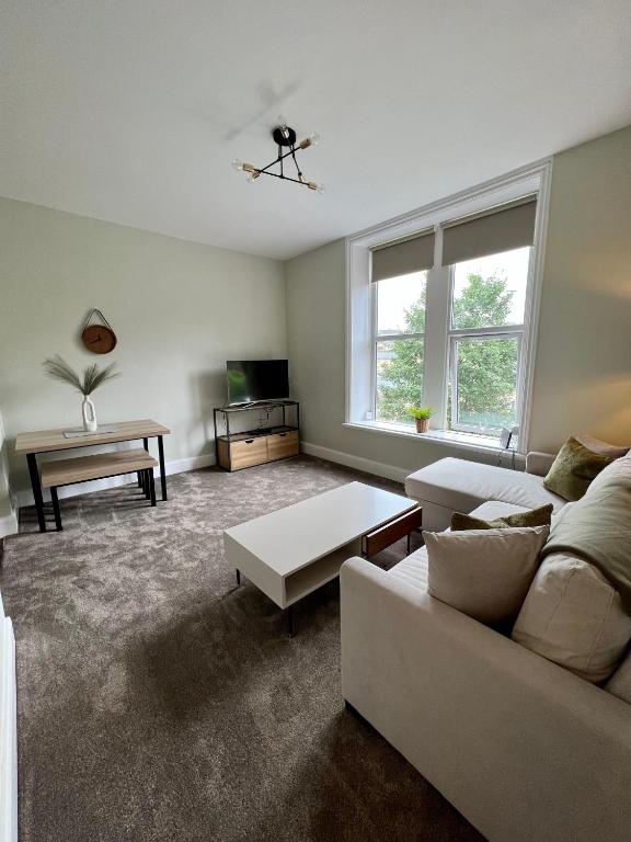 a living room with a couch and a table at The Lookout@brighouse in Brighouse