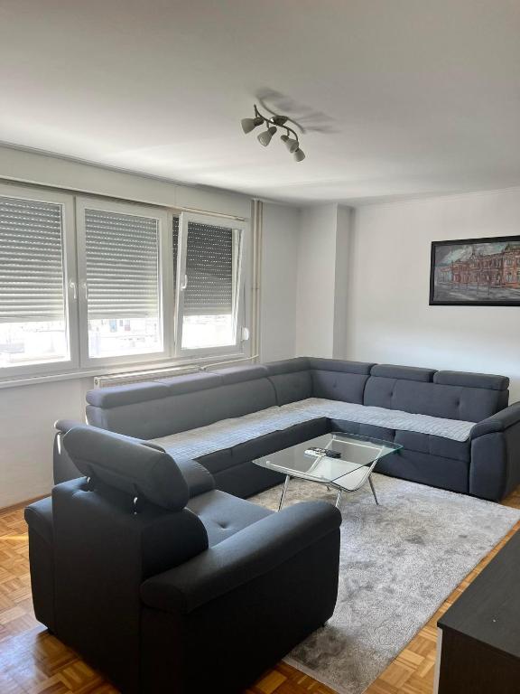 a living room with a couch and a table at ELITE Brcanska Malta in Tuzla