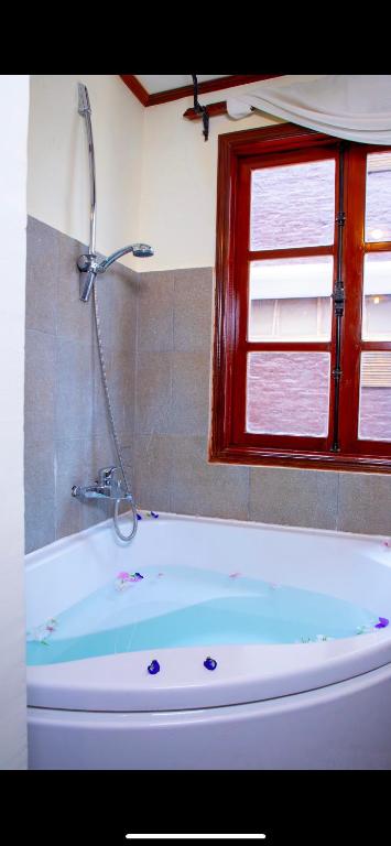 a bath tub with a shower in a bathroom at Phongsavath Boutique Hotel in Vientiane