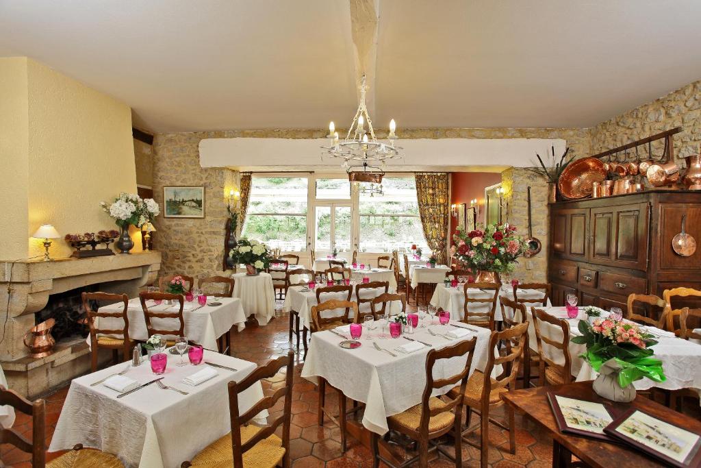 Le Terminus des Pèlerins في روكامادور: غرفة طعام مع طاولات وكراسي ومدفأة