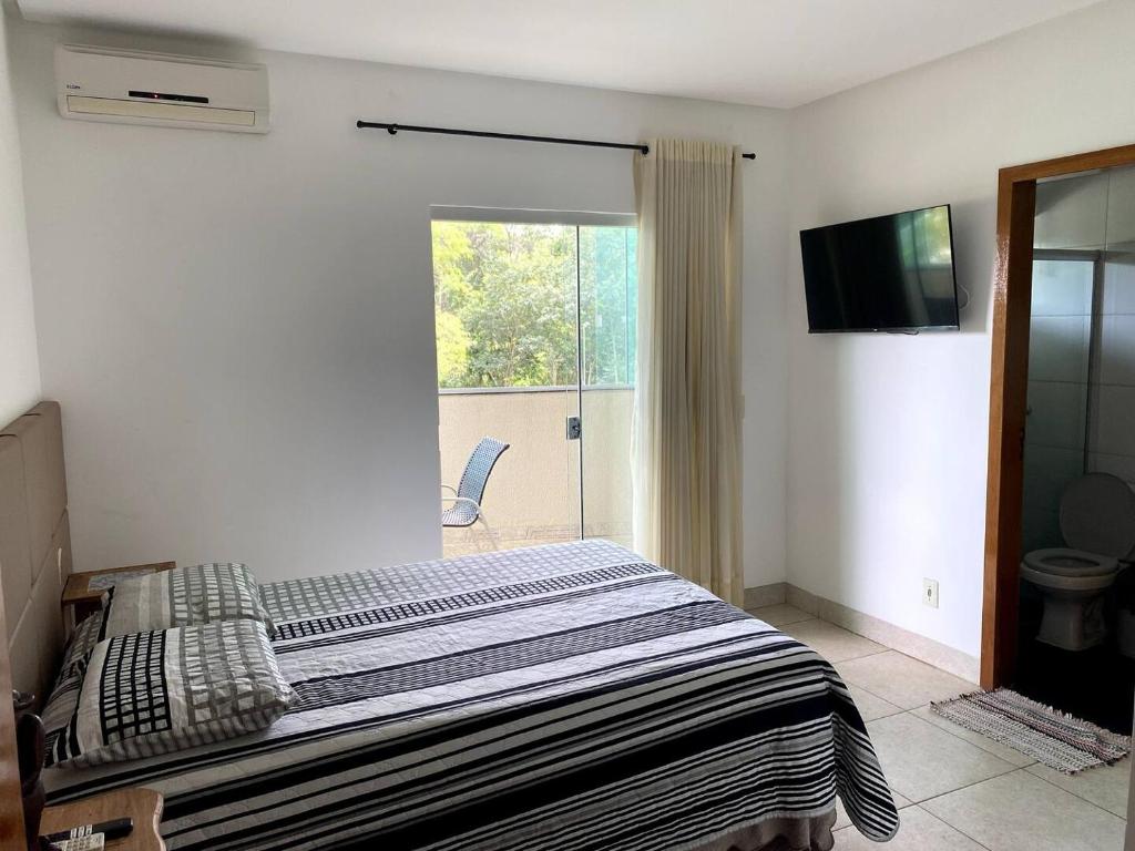 um quarto com uma cama e uma porta de vidro deslizante em 4 Aps baratos, confortáveis, completos e com garagem insta thiagojacomo em Goiânia