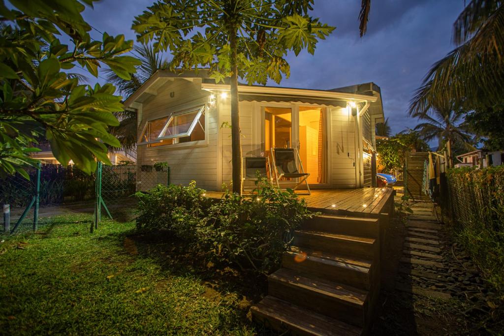 a small house with lights on the front of it at Between2Waters Chalet rental car offered in Tamarin