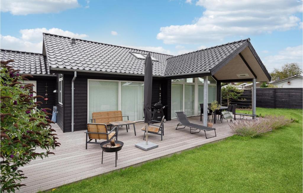 una terraza de madera con parrilla y sillas. en Awesome Home In Karrebksminde With Kitchen, en Karrebæksminde