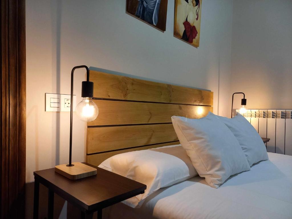 sypialnia z łóżkiem z drewnianym zagłówkiem i stołem w obiekcie Apartamento Ábside de San Juan I w mieście Estella