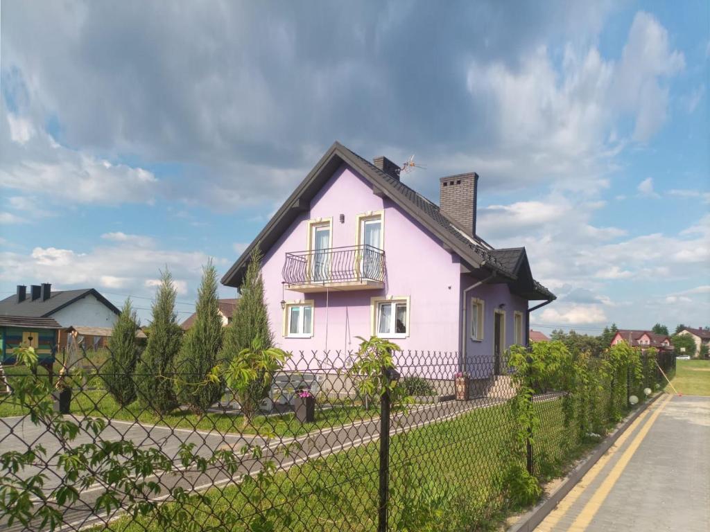 una casa rosa al lado de una carretera en Jagodowy Domek, en Święta Katarzyna