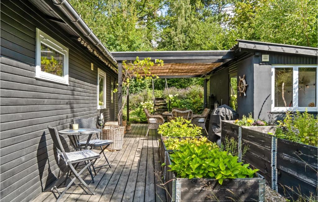 a patio with a table and chairs next to a house at Lovely Home In lsted With Kitchen in Ølsted