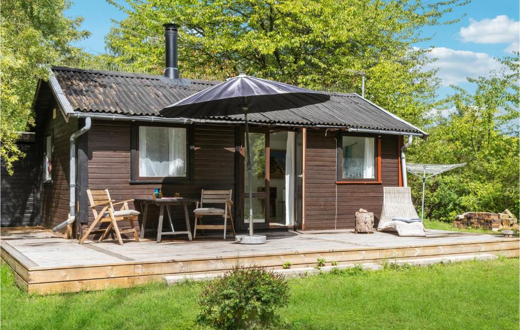 Casa pequeña con sombrilla en una terraza de madera en Stunning Home In Ask With Kitchen 