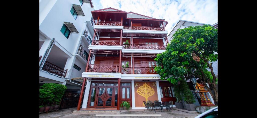 a tall red building with balconies on a street at Phongsavath Boutique Hotel in Vientiane