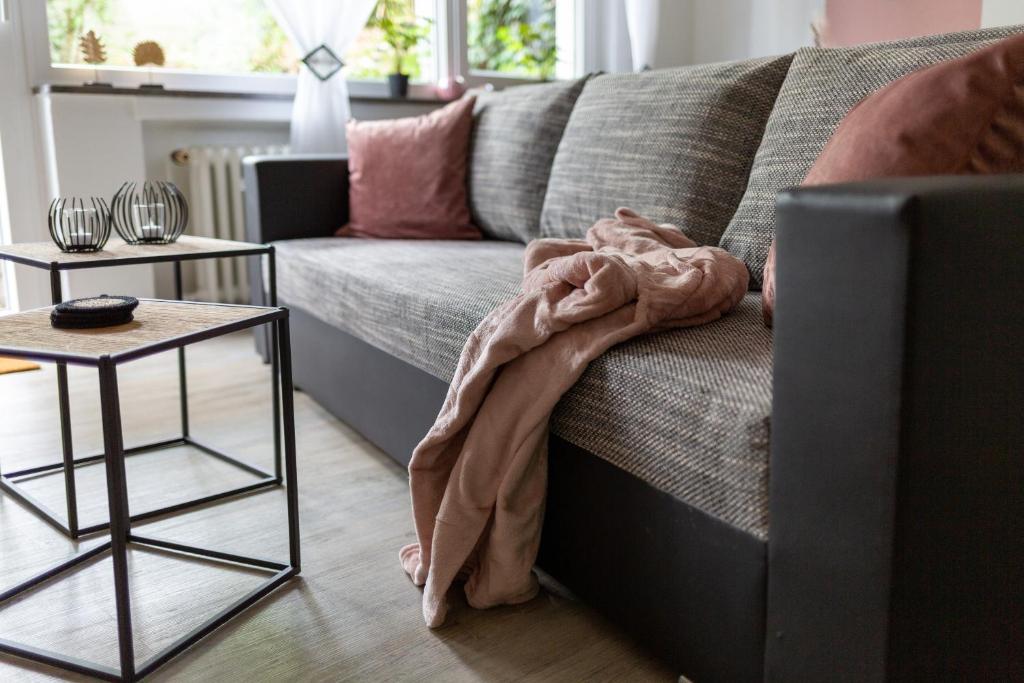 a blanket laying on a couch in a living room at gemütlich und modern - ruhig und zentral in Hünfeld