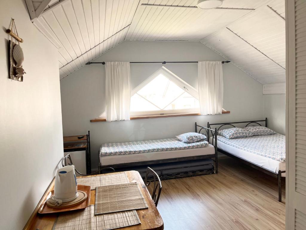 ウェバにあるPokoje gościnne Labaの窓とテーブル付きの部屋のベッド2台