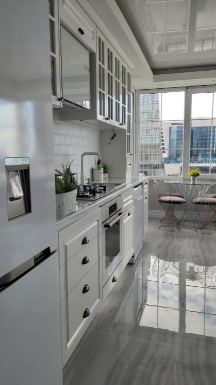 eine Küche mit weißen Schränken und einem großen Fenster in der Unterkunft Modern apartment in Batumi