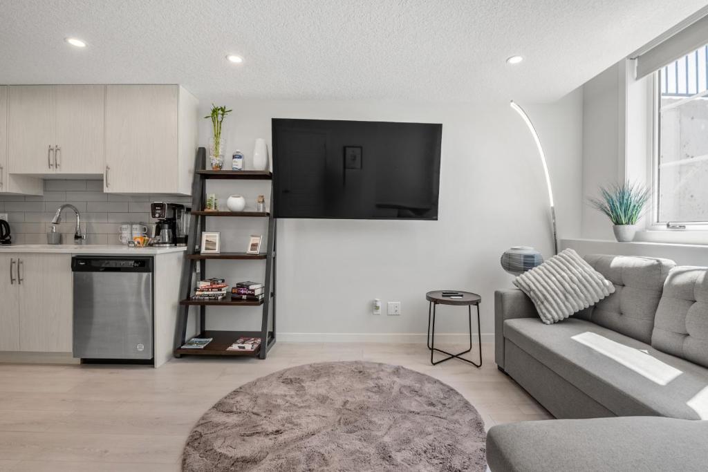 a living room with a couch and a kitchen at Cozy Rockland Park Unit+Parking in Calgary