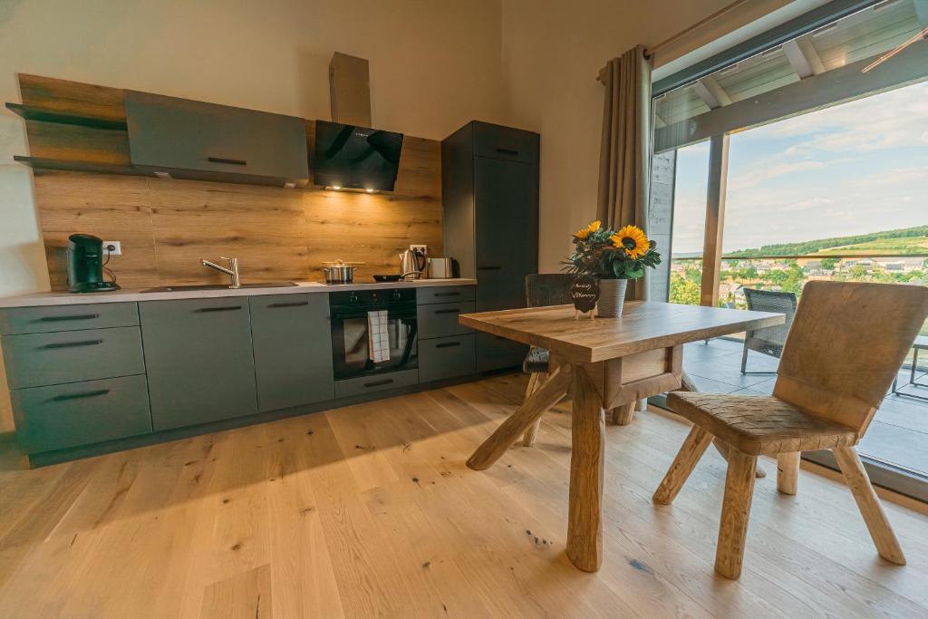 eine Küche mit grünen Schränken und einem Holztisch in der Unterkunft Holzspan in Seiffen