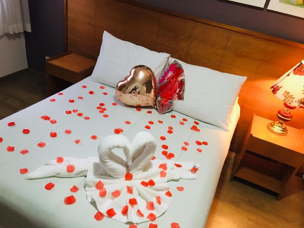 a bed with red hearts on it with a bed at Pousada Condado Brasileiro in Campos do Jordão