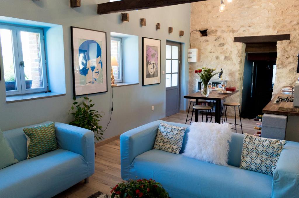 ein Wohnzimmer mit 2 blauen Sofas und einem Tisch in der Unterkunft Petite Maison de Mouton in Azat-le-Riz