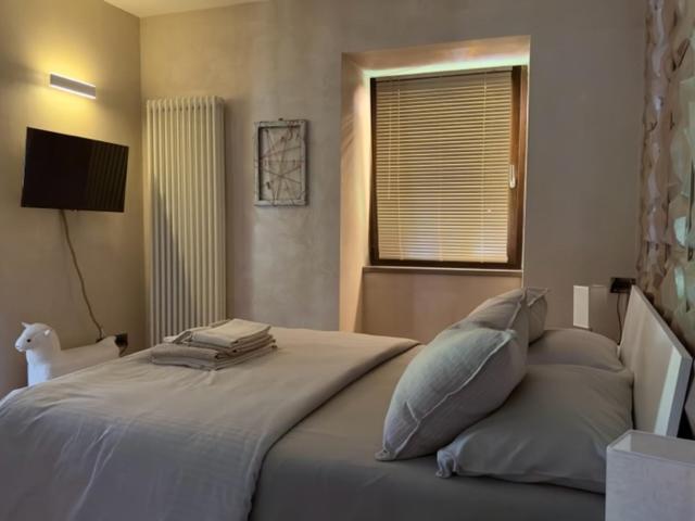 a bedroom with a bed with pillows and a window at Alloggio Turistico MOLU in Gavazzo Nuova