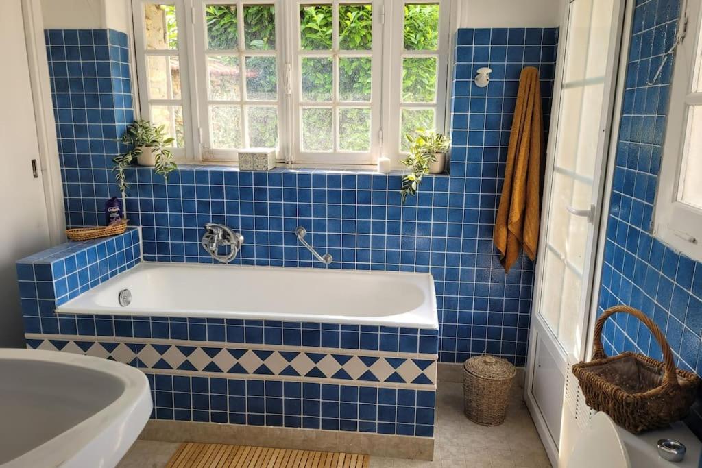 a blue tiled bathroom with a tub and a window at L&#39;Echappée d&#39;Aristide - proche Giverny &amp; 50 min Paris in Houlbec-Cocherel