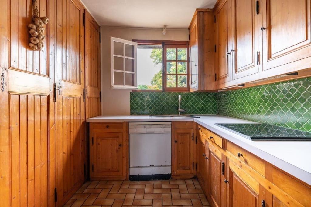 a kitchen with wooden cabinets and a white dishwasher at L&#39;Echappée d&#39;Aristide - proche Giverny &amp; 50 min Paris in Houlbec-Cocherel