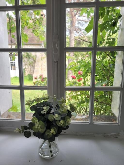 a vase of flowers sitting in front of a window at L&#39;Echappée d&#39;Aristide - proche Giverny &amp; 50 min Paris in Houlbec-Cocherel