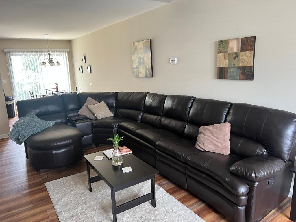 a black leather couch in a living room with a table at Stylish, Cozy Corporate Townhome with Pool! in Greensboro