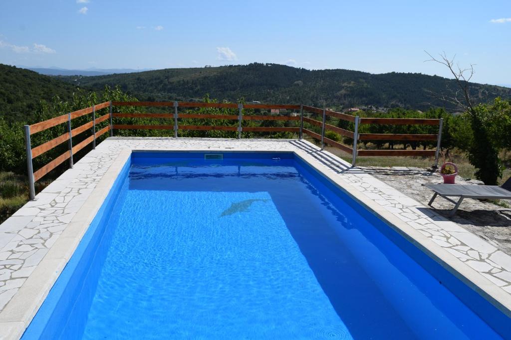Stolac的住宿－Kamena Oaza，蓝色的游泳池,带有围栏和山脉背景