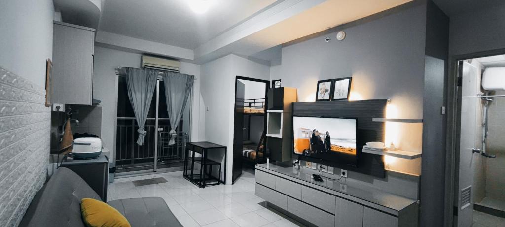 a living room with a flat screen tv on a dresser at Spacious & Cozy 27FL - 2BR Apartment West Jakarta in Jakarta