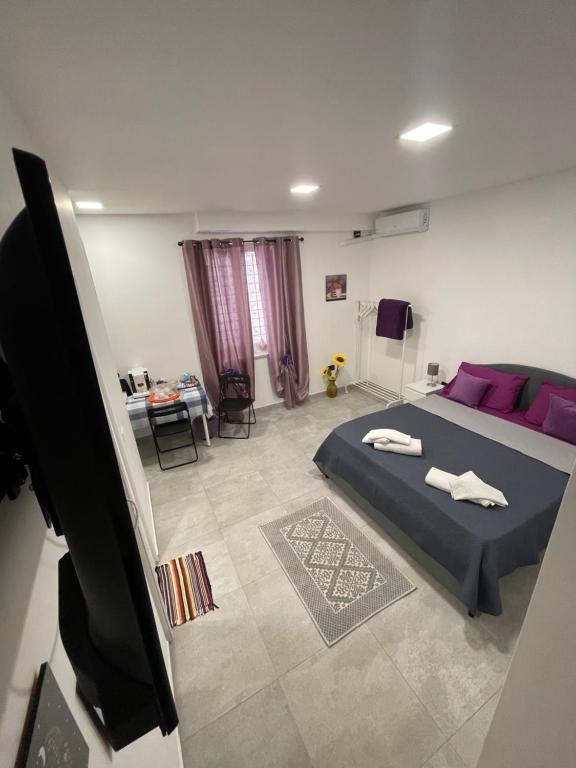 a bedroom with a bed with purple pillows at Tufaro B&B in Macerata Campania