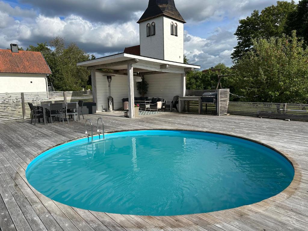 a blue swimming pool on a wooden deck with a church at Hangvar Skola, Bildsalen in Lärbro