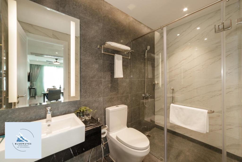 W łazience znajduje się toaleta, umywalka i lustro. w obiekcie Bluewaves Apartment Quy Nhon w mieście Quy Nhơn