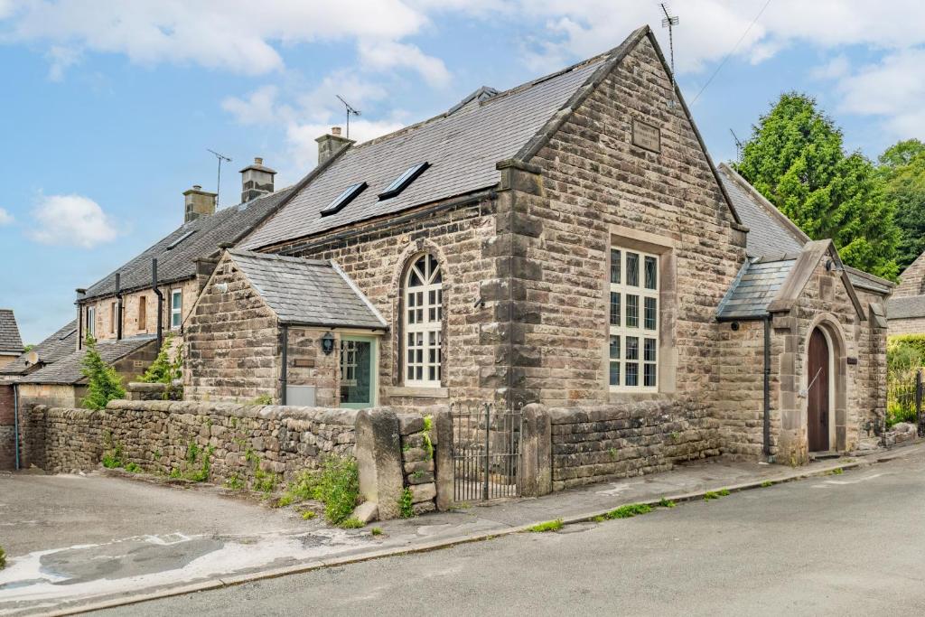 an old stone church with a stone wall at Nine Ladies in Matlock