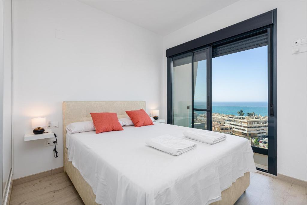 a bedroom with a large white bed with a large window at WintowinRentals New and Sea View in Torre de Benagalbón