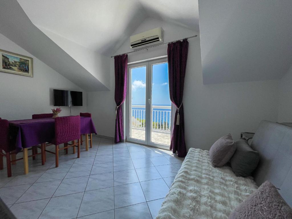 a living room with a couch and a table and a window at Apartments Marija Magdalena in Hvar