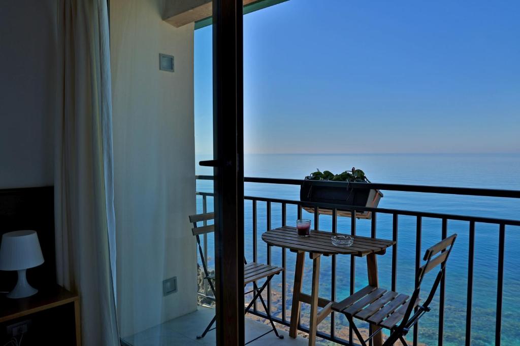 uma varanda com uma mesa e cadeiras e o oceano em Terrazza Roberto em Cefalù