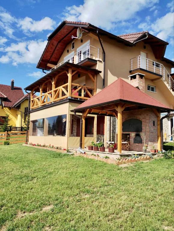 a large house with a large yard in front of it at Apartmani Šarović Tara in Rača
