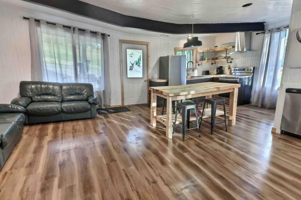 a living room with a table and a couch at Chez Dorance in Saint-Gabriel