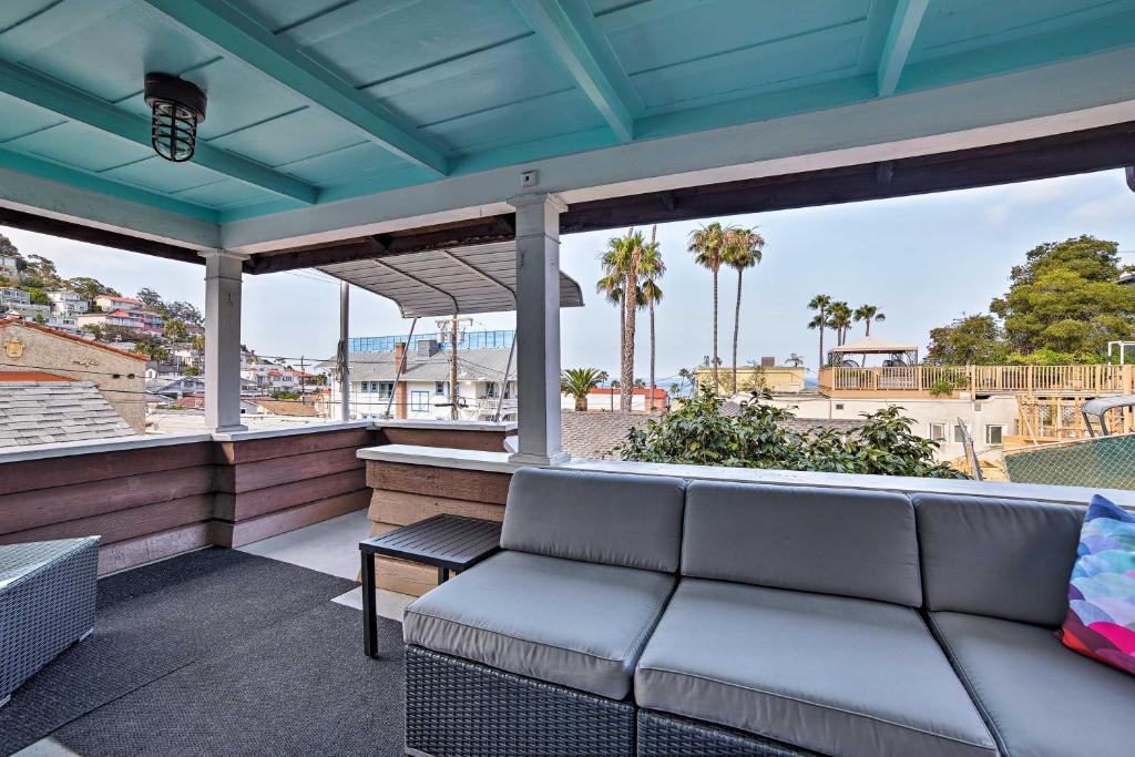 Charming Catalina Gem with Deck Walk to the Beach! في أفالون: أريكة على شرفة مطلة على الشاطئ