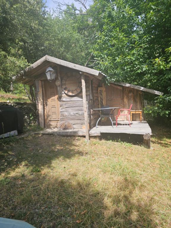a small cabin with a red chair in front of it at Cabane insolite in Saint-Germain-de-Calberte
