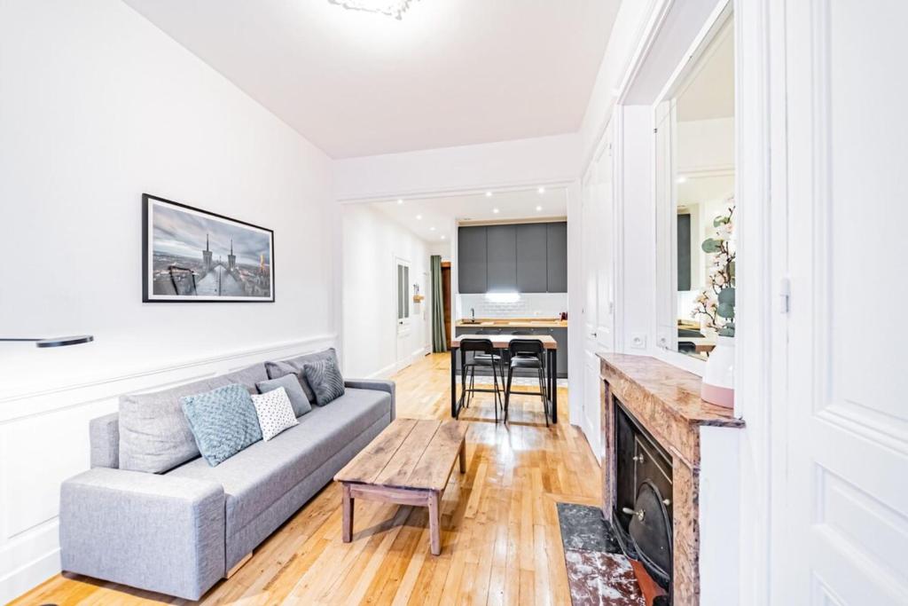 un salon avec un canapé et une table dans l'établissement Aapartment with character Parquet flooring fireplace - Charpennes, à Villeurbanne