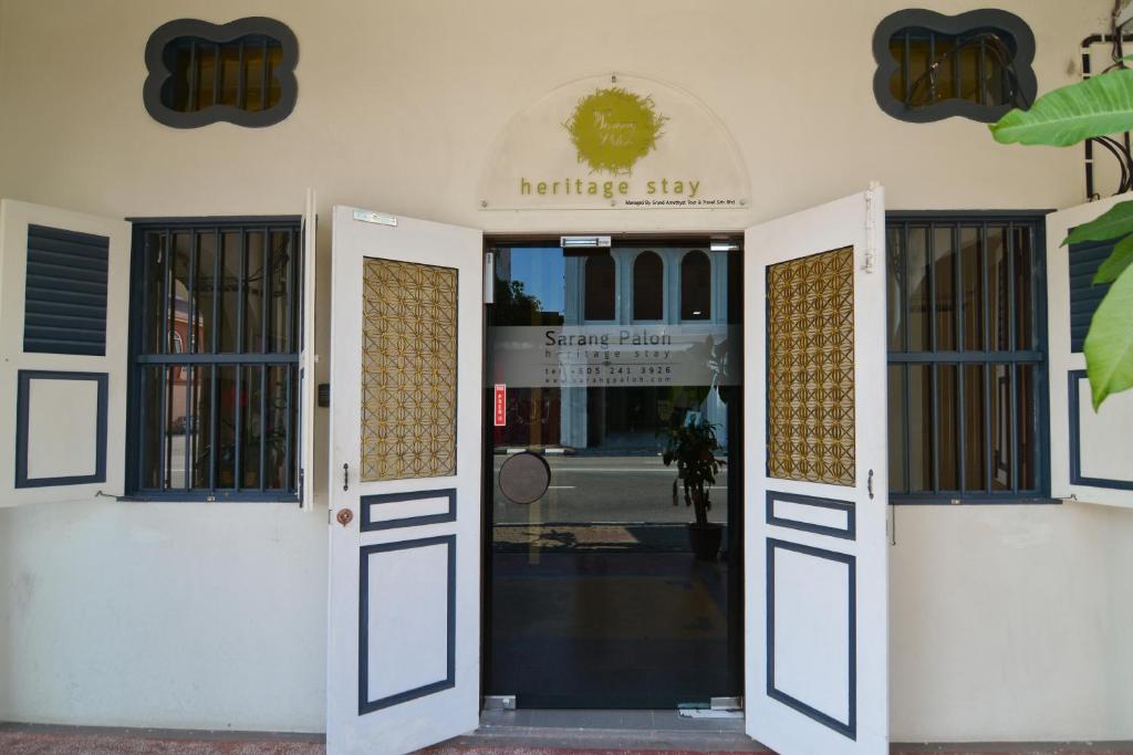 una puerta abierta de un edificio con un cartel. en Sarang Paloh Heritage Stay en Ipoh