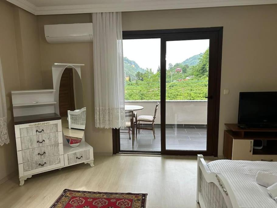 een slaapkamer met een bed en een balkon met een tafel bij 4+2 Villa Right Middle of Nature in Yomra