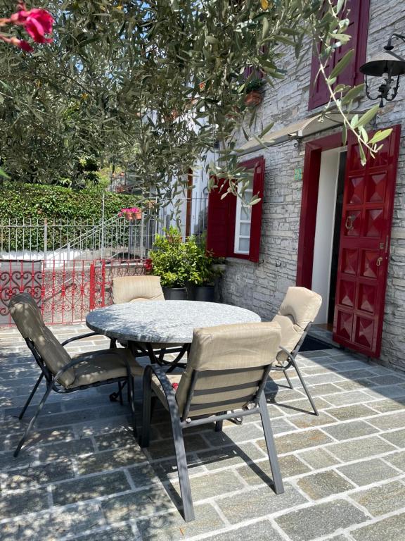 stół i krzesła na patio przed budynkiem w obiekcie Ester Lakehouse, graziosa casa indipendente w mieście Lierna