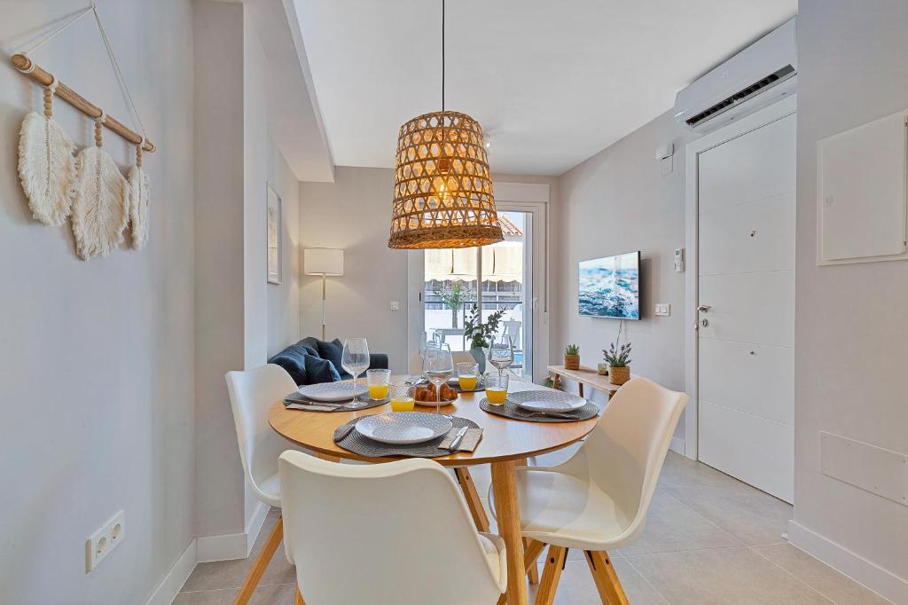 a dining room with a table and white chairs at Angelica's Home Fuengirola in Fuengirola