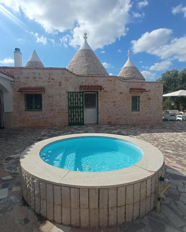 dom z basenem przed nim w obiekcie Villa Il Leccio - Trulli w mieście Cisternino