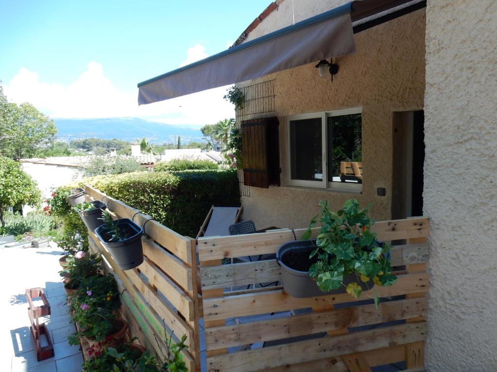 a fence with potted plants on the side of a house at Studio saisonnier in La Roquette-sur-Siagne